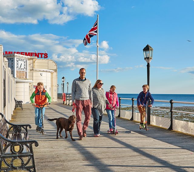 A family walking their dog along the pier in Worthing