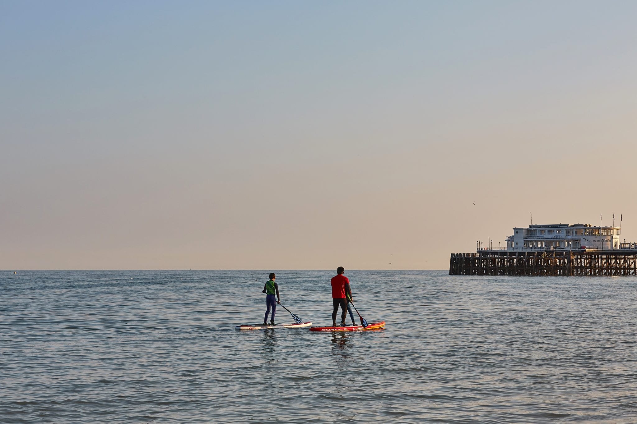 Two people paddleboarding near Worthing Pier